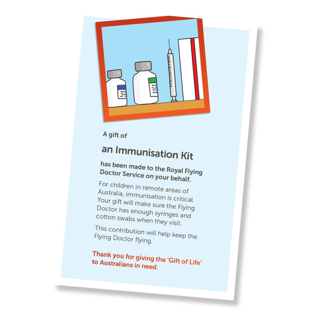 A card for a donation of an immunisation kit, shown at an angle on a white background. The card has a pale blue field, a small illustrated header with medical bottles, a syringe, and a red-orange border, and text stating it is a gift of an immunisation kit and a that it is a donation to the Royal Flying Doctor Service.