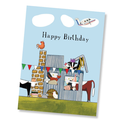 A Happy Birthday greeting card featuring a whimsical farm scene with cows, a chicken, a pig, a rooster, an RDFS plane, and bunting under a light blue sky. The card is shown at a slight angle on a white background.